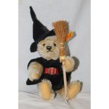 A Steiff 2003 "Hexe" witch teddy bear, wearing a witches hat, a cape, holding a broom,