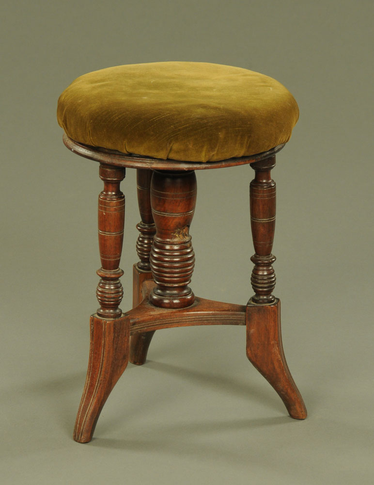 A late Victorian rosewood circular adjustable piano stool of aesthetic design,