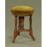 A late Victorian rosewood circular adjustable piano stool of aesthetic design,
