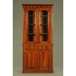 A Victorian figured mahogany bookcase, with moulded cresting,