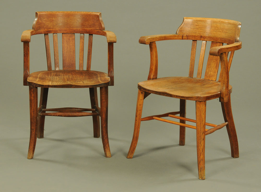 A pair of 1920's oak office open armchairs, on simple splayed front legs.