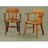 A pair of 1920's oak office open armchairs, on simple splayed front legs.