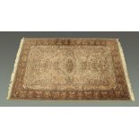 A Persian design woollen fringed carpet, principal colours beige blue and green,