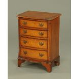 A reproduction walnut bow fronted chest of drawers,