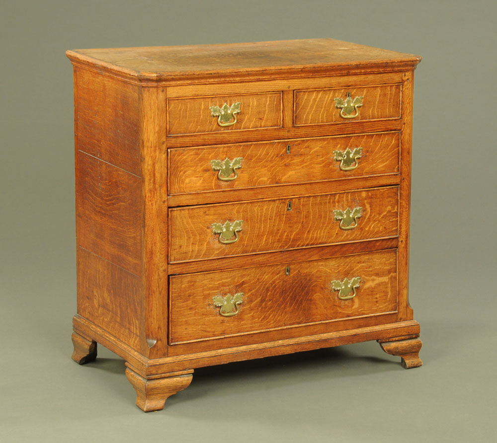 A George III oak chest of drawers with canted front corners,