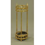 An Edwardian circular brass hall stick stand, with later drip tray. Height 65 cm, diameter 23 cm.