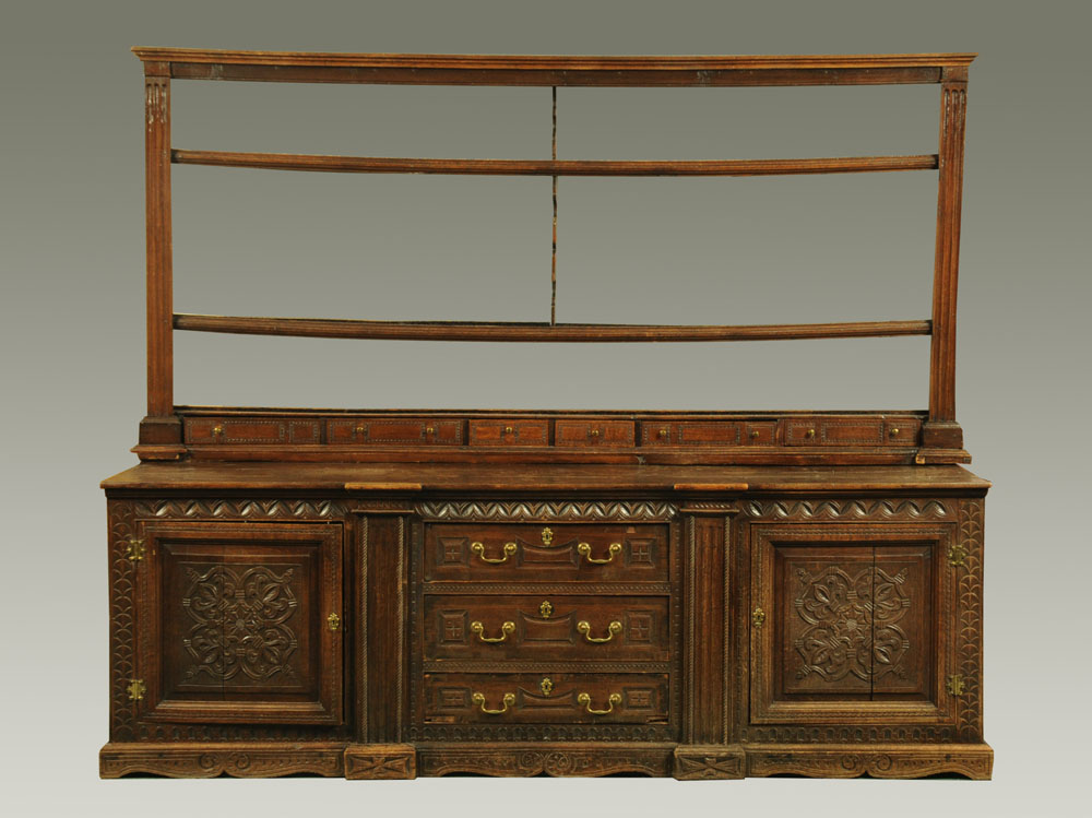 A George III panelled oak dresser, the open rack fitted six drawers,