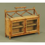 A late Victorian bamboo hanging cupboard, with shelf above a pair of glazed doors.