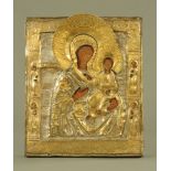 A Russian icon, relief moulded brass and paint over wood with Russian papers attached verso.