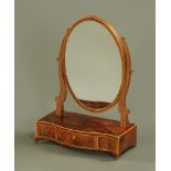 A George III style mahogany oval toilet mirror with serpentine base, fitted with three drawers.