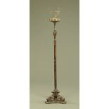 A carved wooden lamp standard, with three downswept scroll legs and triform base.