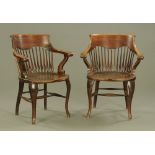 A pair of 1920's oak open armchairs, with baluster spindle backs,