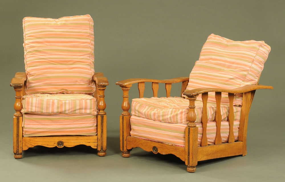 A pair of 1930's oak recliner armchairs, with slatted sides on turned front supports.