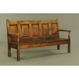 An 18th century oak five panelled settle, with outswept arms,