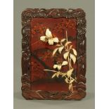 An Oriental lacquered panel, decorated in relief with lilies. Height 73 cm, width 51 cm.