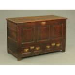 An 18th century panelled oak mule chest, fitted two drawers, 80 cm high, 128 cm wide, 58 cm deep.