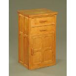 A panelled light oak bedside chest, fitted two drawers and cupboard,