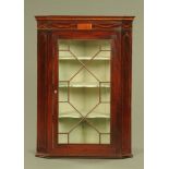 A George III inlaid mahogany hanging corner cupboard, with glazed door,