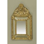 A late 19th century continental embossed brass wall mirror,