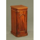 A Victorian mahogany narrow bedside cabinet, with rounded corners panelled door and plinth base.