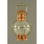 A Victorian copper and brass mounted tilly lamp, with spherical clear glass shade.