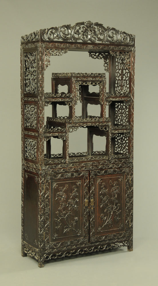 A 19th century Chinese hardwood cabinet in two sections,