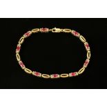 A gold coloured metal diamond and ruby set tennis bracelet, stamped 9 k, 6.3 grams, length 19.