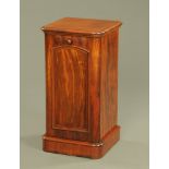 A Victorian mahogany bedside cabinet, with single panelled door and raised on a plinth.