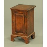 A reproduction oak bedside cabinet, with moulded edge,