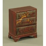 A Japanese miniature chest of two short and two long drawers, raised on bracket feet.