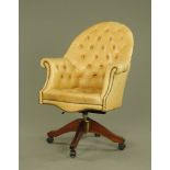 A Victorian style deep buttoned beige leather revolving desk chair,