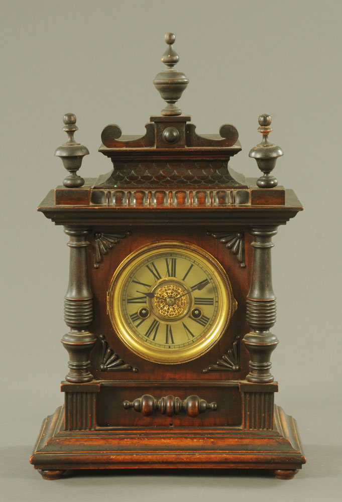 An Edwardian walnut mantle clock, with two train striking movement and raised on short bun feet.