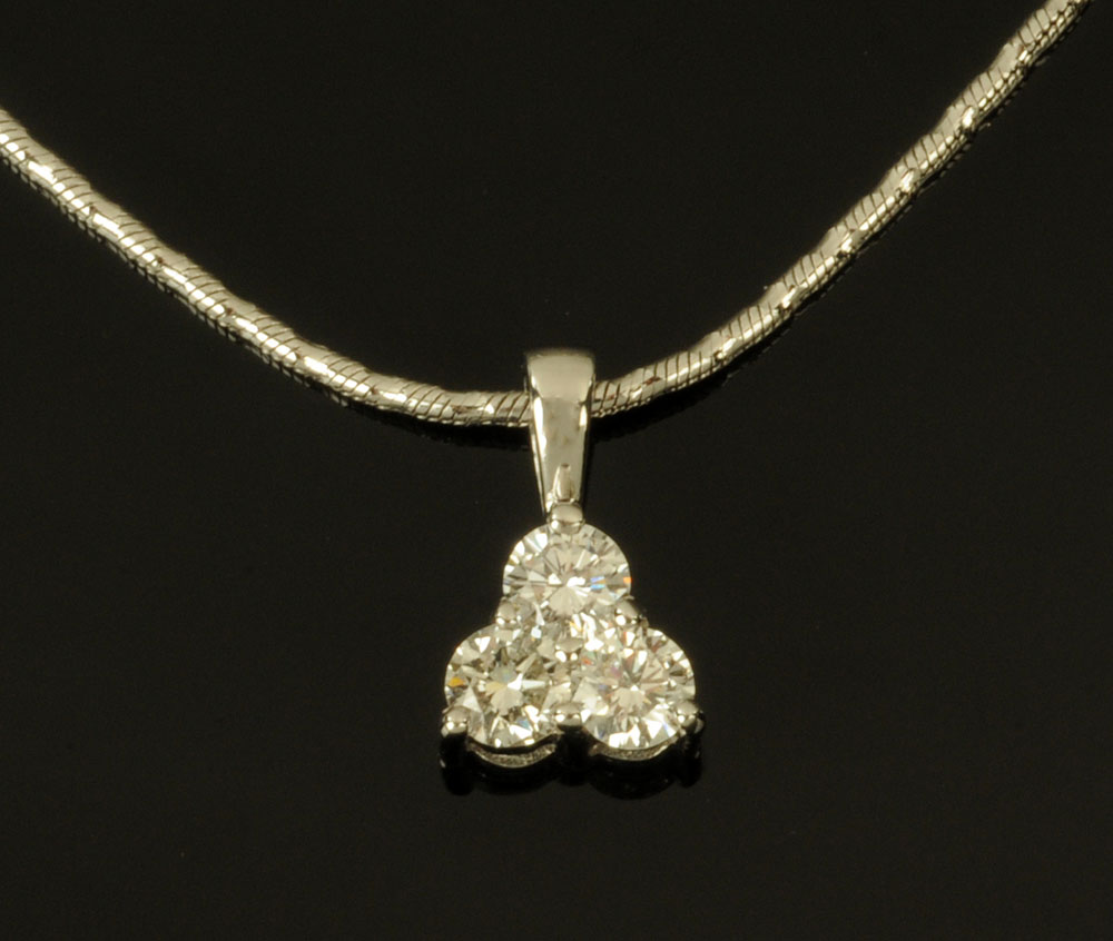 An 18 ct white gold trefoil pendant on chain, set with diamonds weighing +/- .60 carats.