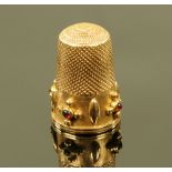 A gold coloured metal gemstone set thimble, cased. 5.3 grams gross.