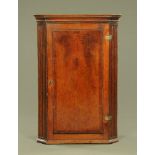 A George III mahogany corner cupboard, with fluted canted corners,