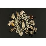A silver charm bracelet with large quantity of charms, gross weight 108 grams.