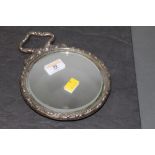 An Edwardian silver mounted mirror with embossed cherub design