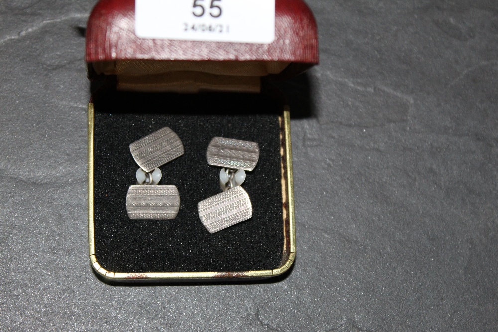A pair of engine turned white metal cufflinks,