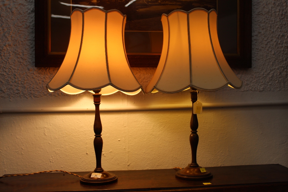 A pair of turned oak table lamps and shades,