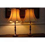 A pair of turned oak table lamps and shades,