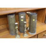 Pair of brass candlesticks, single candlesticks and three brass shell cases, 33 cm tall,
