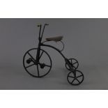 A reproduction cast and wrought iron penny farthing style velocipede, with wooden handles,