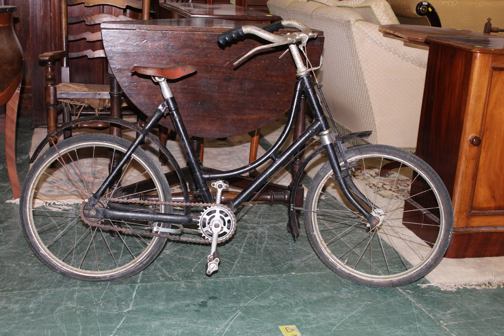 A mid-20th century bicycle, having a black painted and bowed frame,