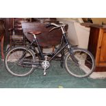 A mid-20th century bicycle, having a black painted and bowed frame,