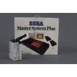 A 180s Sega Master System Plus, with its box, and sold together with three Sega games,