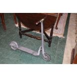 A vintage aluminium metal scooter, with wooden handle bars,