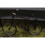 A mid 20th century bicycle, overpainted in maroon, having a bowed frame,