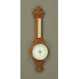 A carved oak banjo barometer, circa 1930 with ceramic dial and mercury thermometer. Height 84 cm.