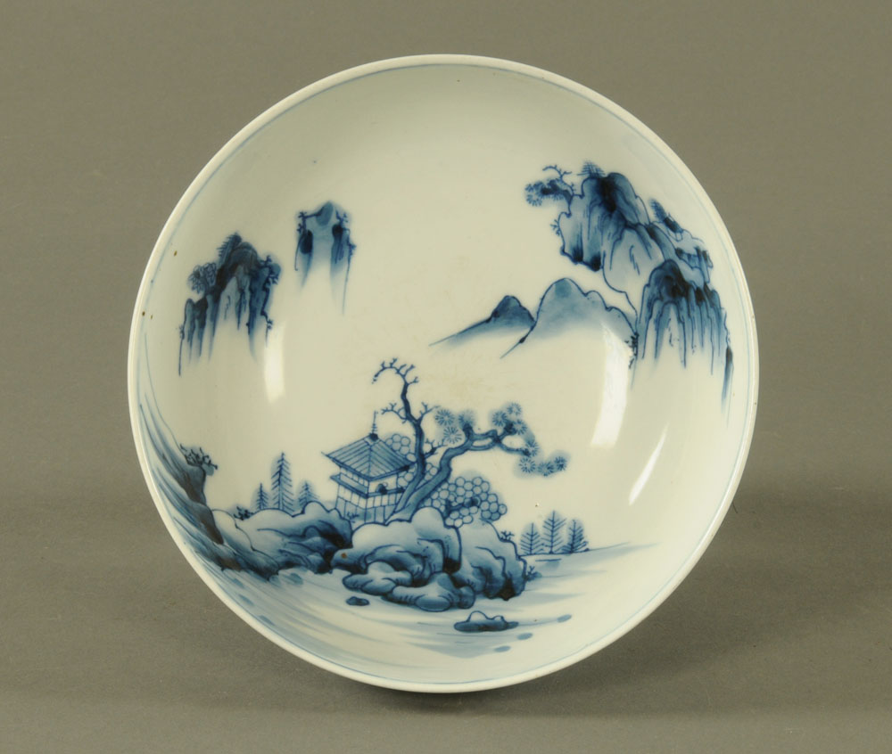 A Japanese blue and white bowl, with repeating foliate design and Pagoda mountain scene to centre.