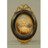 A 19th century primitive portrait miniature of a young girl in landscape, in wooden and metal frame.